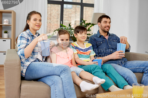 Image of happy family with popcorn watching tv at home