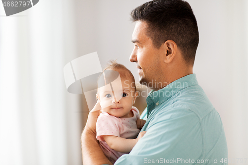 Image of middle aged father with baby daughter at home
