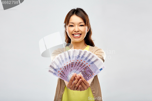 Image of asian woman with hundreds of euro money banknotes