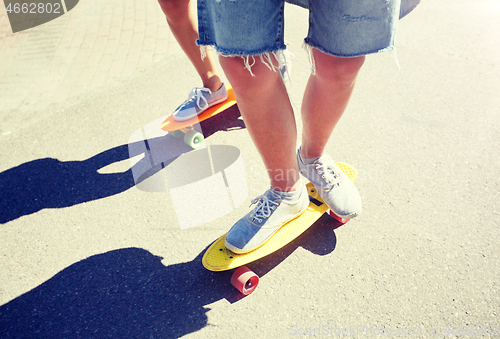 Image of teenage couple riding skateboards on city road