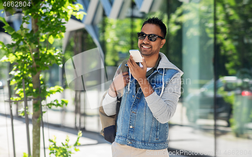 Image of man recorving voice message on smartphone in city