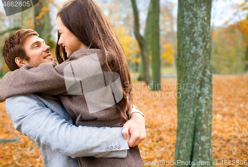 Image of smiling couple hugging in autumn park