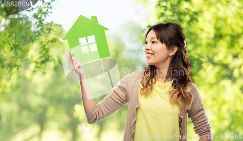 Image of woman with green house over natural background