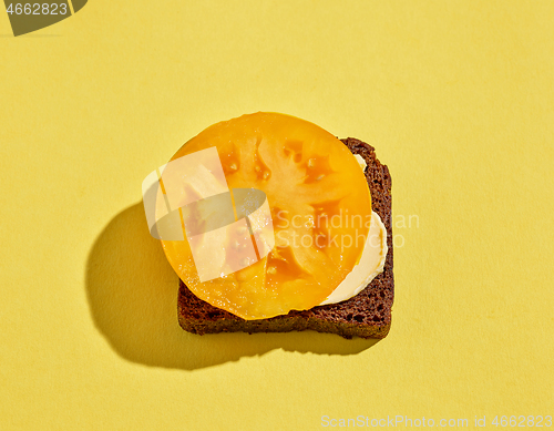 Image of bread with butter and yellow tomato