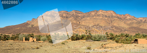 Image of Moroccan clay houses near mountains and palms