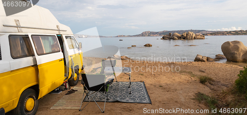 Image of Old colorful retro camper van on camping site at beautiful rocky coastal landscape of Costa Smeralda, north east Sardinia, Italy. Tourism vacation and travel.