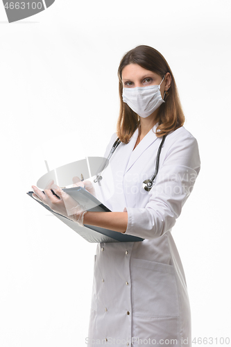 Image of Girl doctor makes notes in the medical history on a tablet