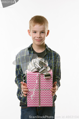 Image of A boy holds a birthday gift in his hands