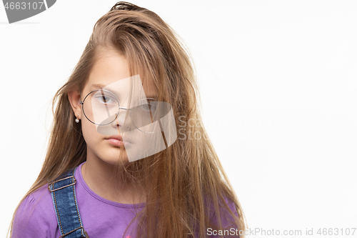 Image of Portrait of a girl of eleven years on a white background with an original hairstyle