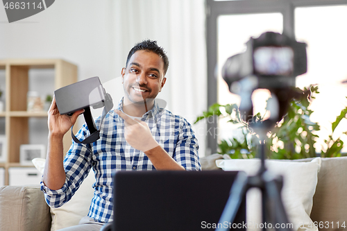 Image of male blogger with vr glasses videoblogging at home