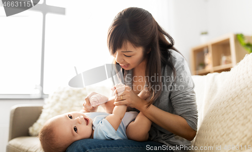 Image of happy young mother with little baby son at home