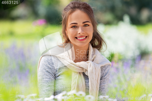 Image of young woman with flowers at summer garden