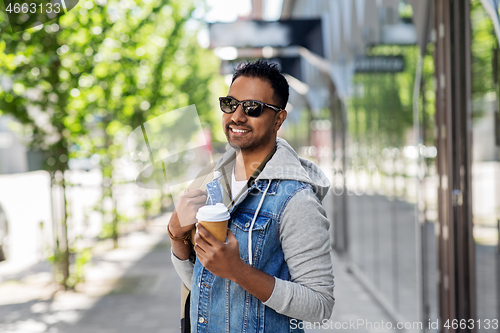 Image of indian man with bag and takeaway coffee in city