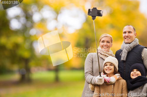 Image of happy family with smartphone and monopod in park