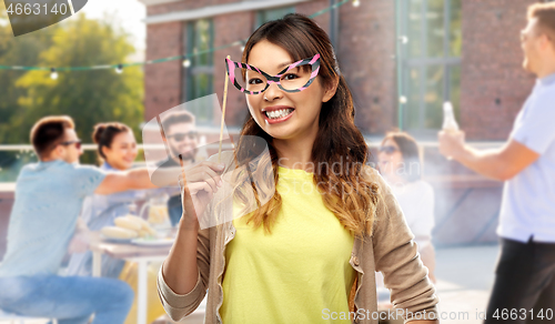 Image of asian woman with big party glasses over rooftop