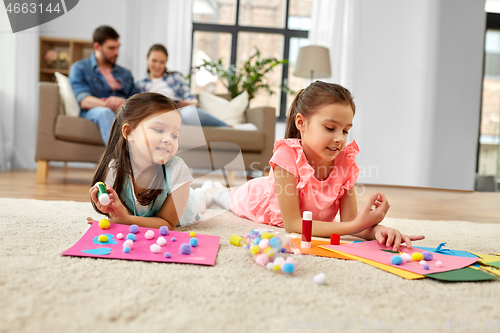 Image of happy sisters doing arts and crafts at home