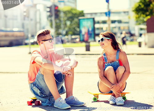 Image of teenage couple with skateboards on city street