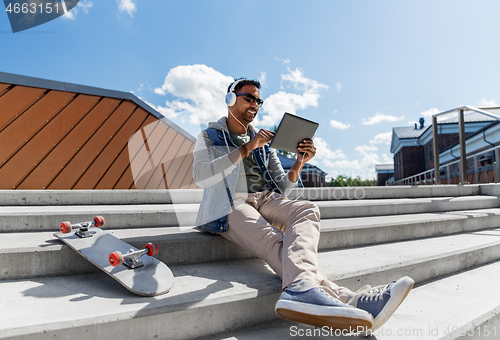 Image of man with tablet pc and headphones on roof top