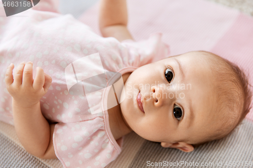 Image of sweet baby girl lying on knitted blanket