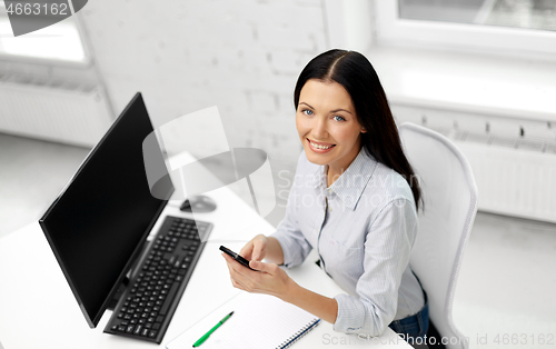 Image of businesswoman using smartphone at office