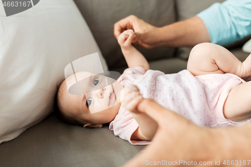 Image of middle aged father playing with baby at home