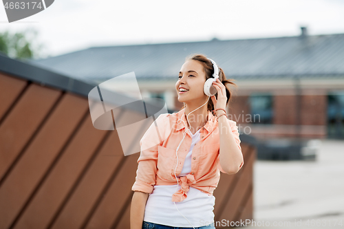 Image of happy teenage girl with headphones in city