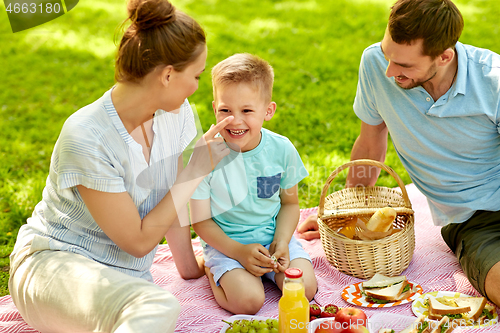 Image of happy family having picnic at summer park