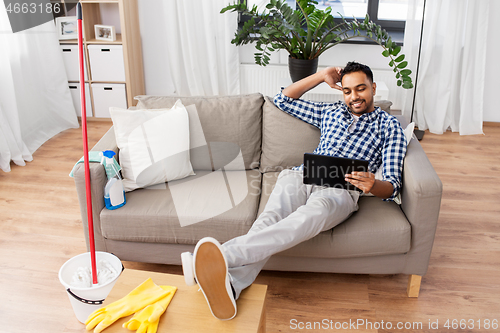 Image of man with tablet computer after home cleaning