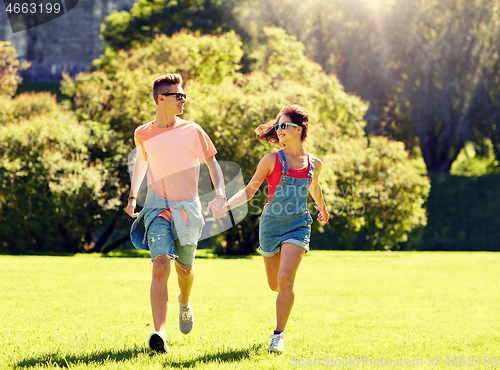 Image of happy teenage couple running at summer park