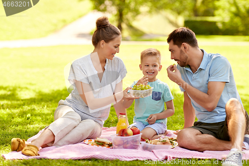 Image of happy family having picnic at summer park