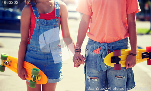 Image of close up of young couple with skateboards in city