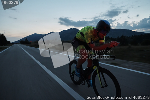 Image of triathlon athlete riding bike at night