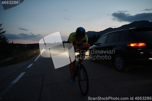 Image of triathlon athlete riding bike at night