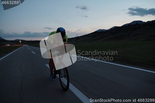 Image of triathlon athlete riding bike at night