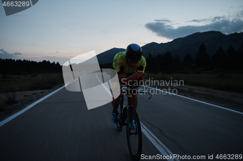 Image of triathlon athlete riding bike at night