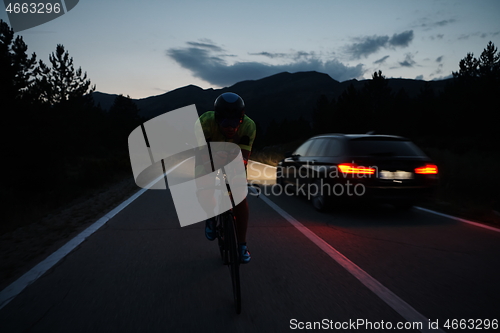 Image of triathlon athlete riding bike at night