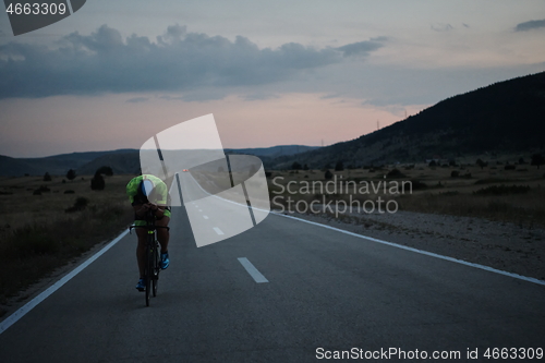 Image of triathlon athlete riding bike at night