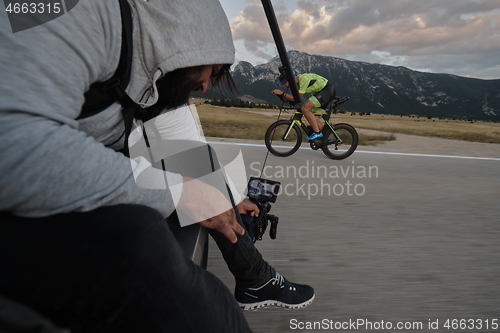 Image of cinematographer taking action shot of triathlon bike athlete