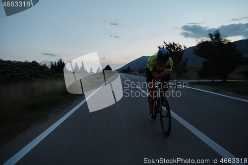 Image of triathlon athlete riding bike at night