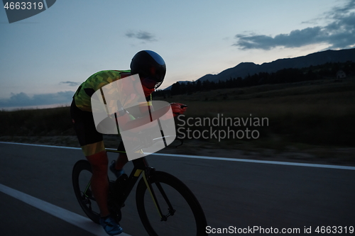 Image of triathlon athlete riding bike at night