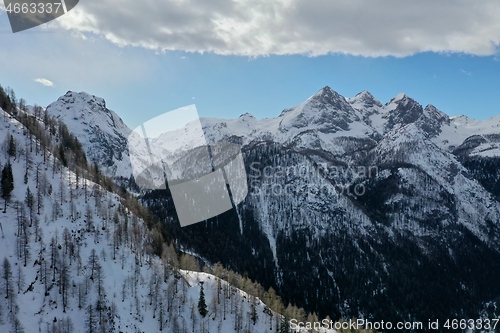 Image of aerial snow covered mountain peaks in alps at winter 