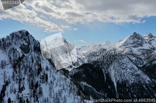 Image of aerial snow covered mountain peaks in alps at winter 