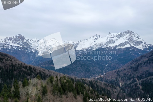 Image of aerial snow covered mountain peaks in alps at winter 