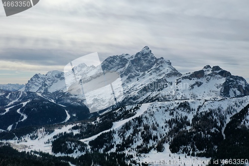 Image of aerial snow covered mountain peaks in alps at winter 