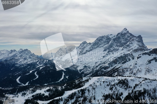 Image of aerial snow covered mountain peaks in alps at winter 