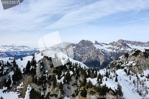 Image of aerial snow covered mountain peaks in alps at winter 