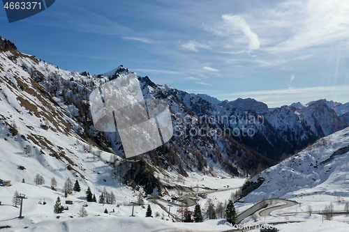 Image of aerial snow covered mountain peaks in alps at winter 