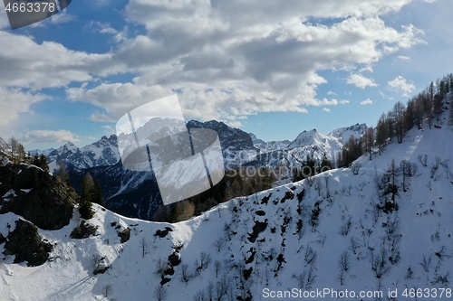 Image of aerial snow covered mountain peaks in alps at winter 