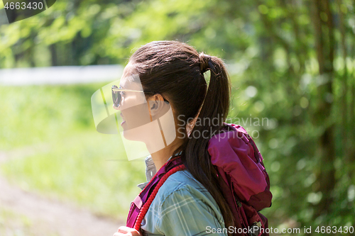 Image of happy young woman with backpack hiking