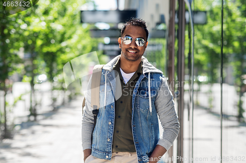 Image of indian man in sunglasses with backpack in city